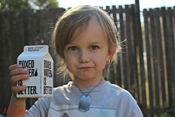 Little boy holding boxed water