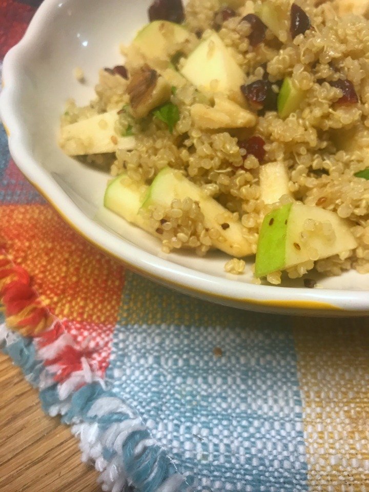bowl of cranberry apple quinoa salad on a placemat.