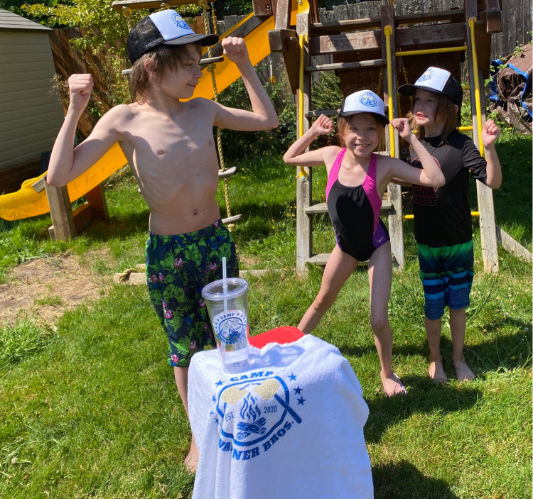 kids in bathing suits by a swingset showing off their muscles