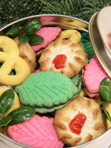 Closeup of a tin of cookies under the Christmas tree.