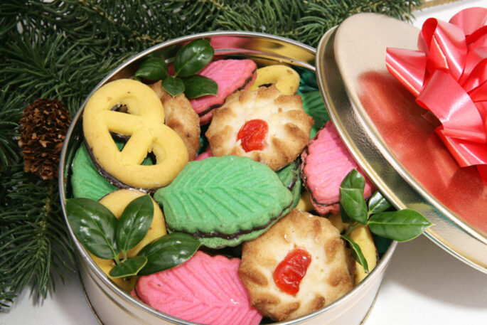 Closeup of a tin of cookies under the Christmas tree.