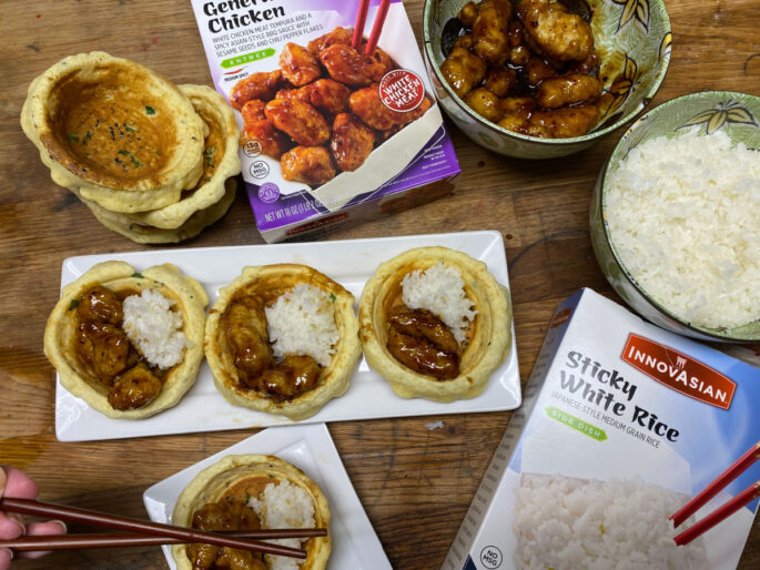 chicken and rice in waffle bowls on white plates with innovasian packaging