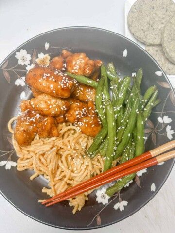 asian inspired meal in black bowl with chopsticks